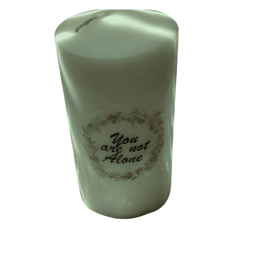 Handmade sage green pillar candle with You Are Not Alone floral wreath design
